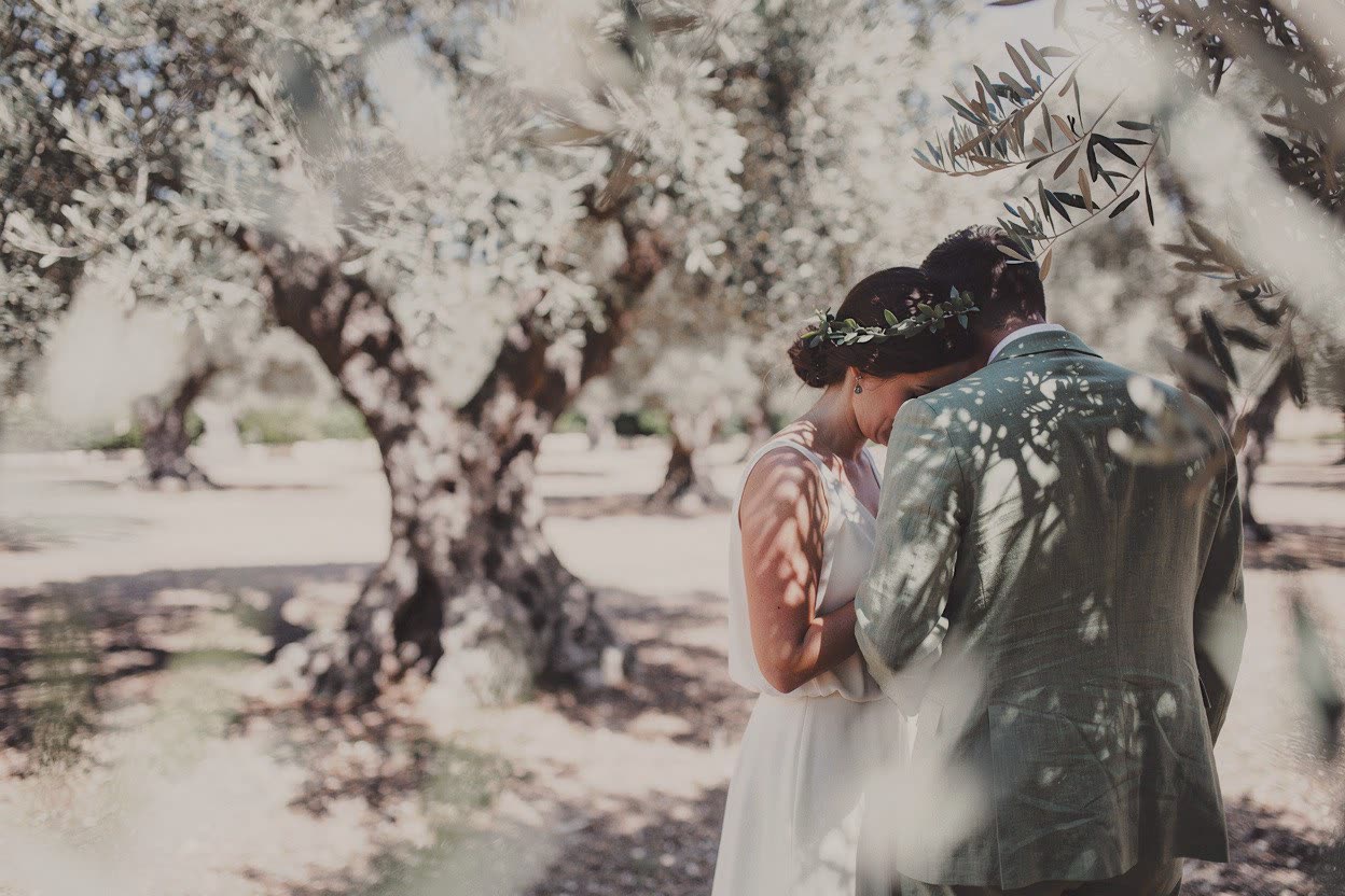 A bride and groom close together in an olive grove, developed in Analog Signature